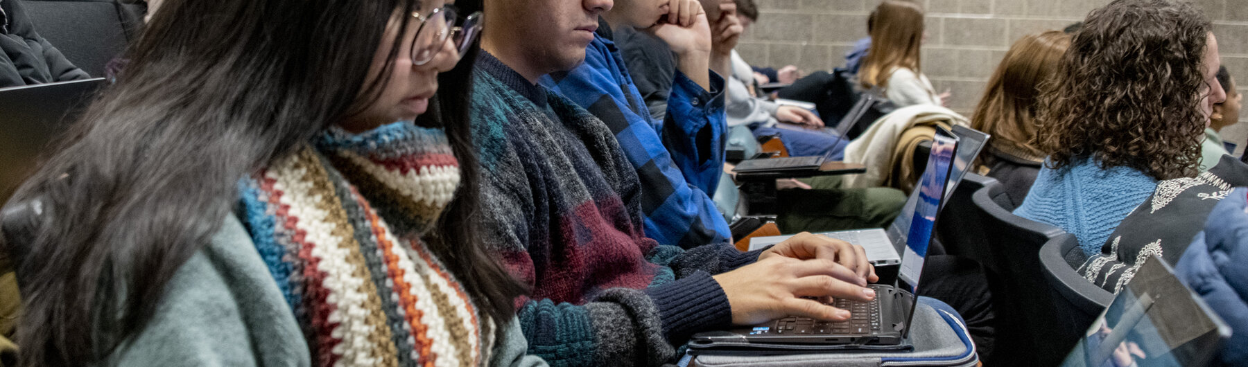 Students taking notes on their laptops in a course