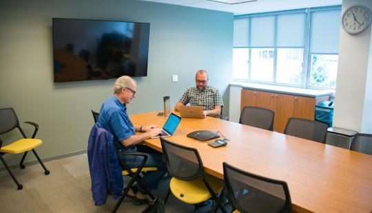 Two men sitting at a table in conference room 340